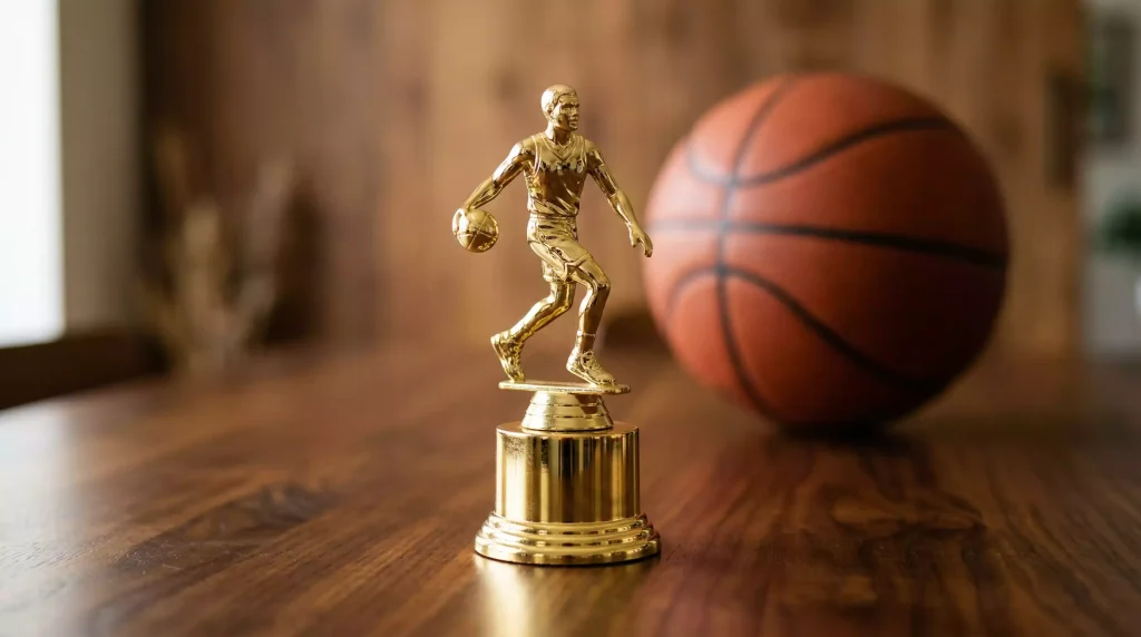 Trofeo del premio MVP de la NBA sobre una mesa con un balón de baloncesto al fondo